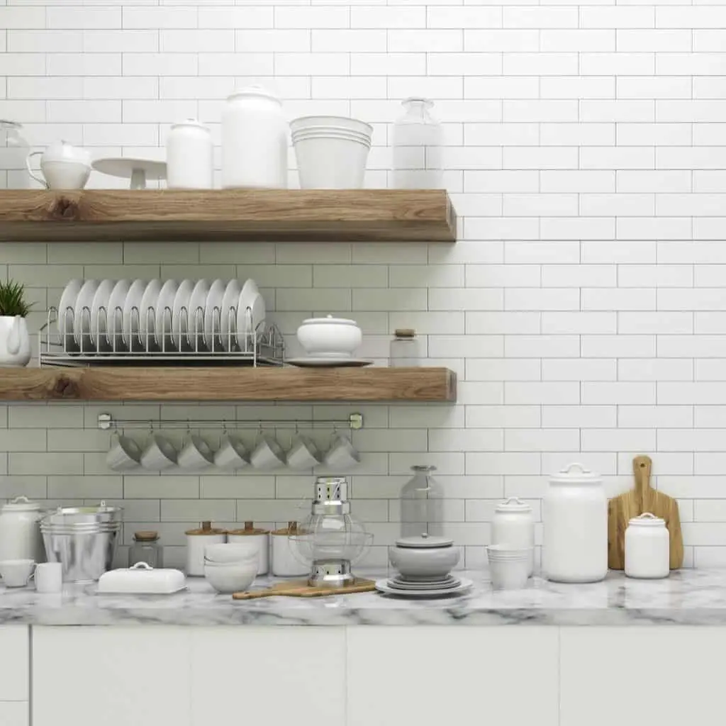 Thick wood floating shelves with various white and glass dishware and kitchen items. There are also some jars with labels and a few wood kitchen items mixed in as well.
