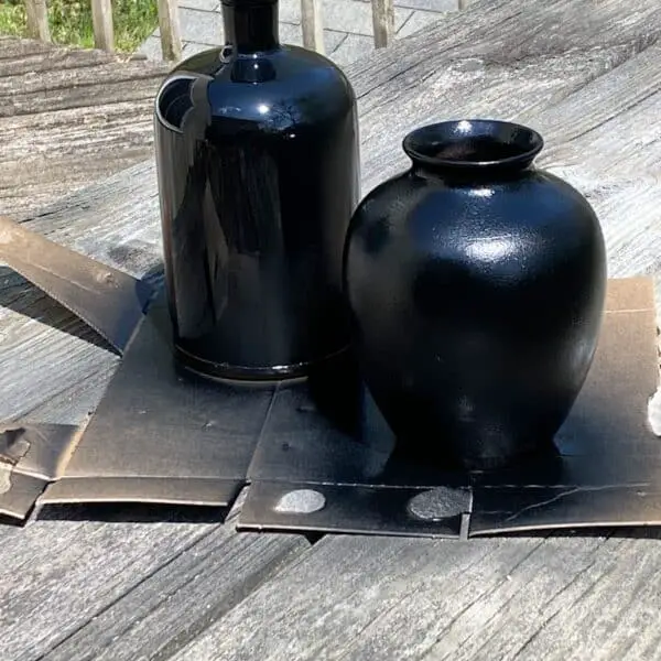 2 upcycled vases after being spray painted with 2 coats of matte black spray paint.