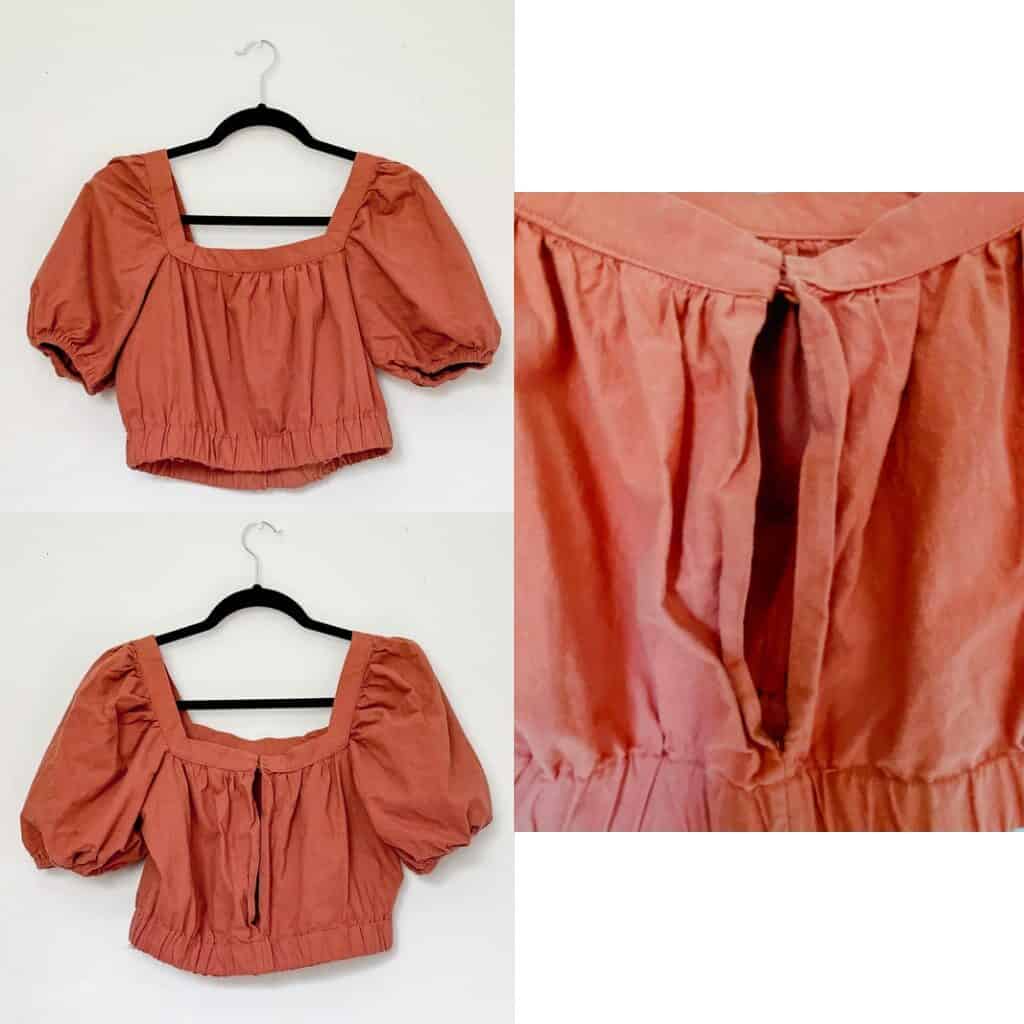 A rust colored cropped shirt with balloon sleeves that are short and an elastic waistband. There is a large keyhole in the back of the top with a 2 button closure at the top.