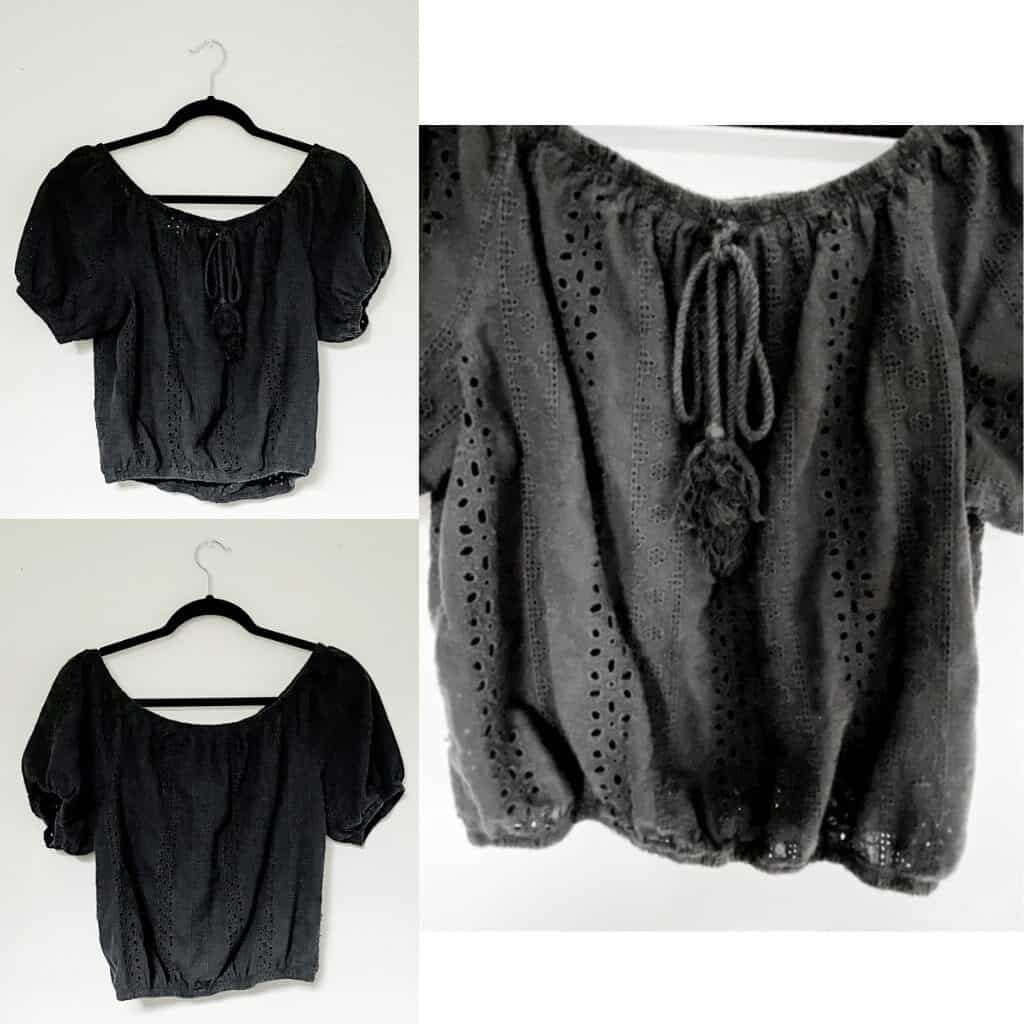 A black eyelet cropped shirt with puff sleeves, elastic around the hems for a tight fit, and a rope tassel tie at the neckline.