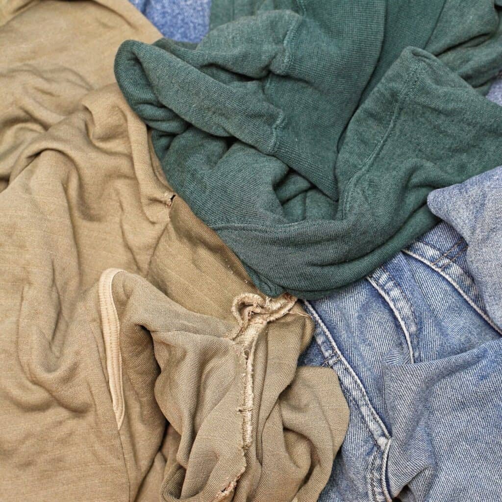 A pile of old shirts and jeans. Make them into rags to use around the house as a method for recycling old clothes.