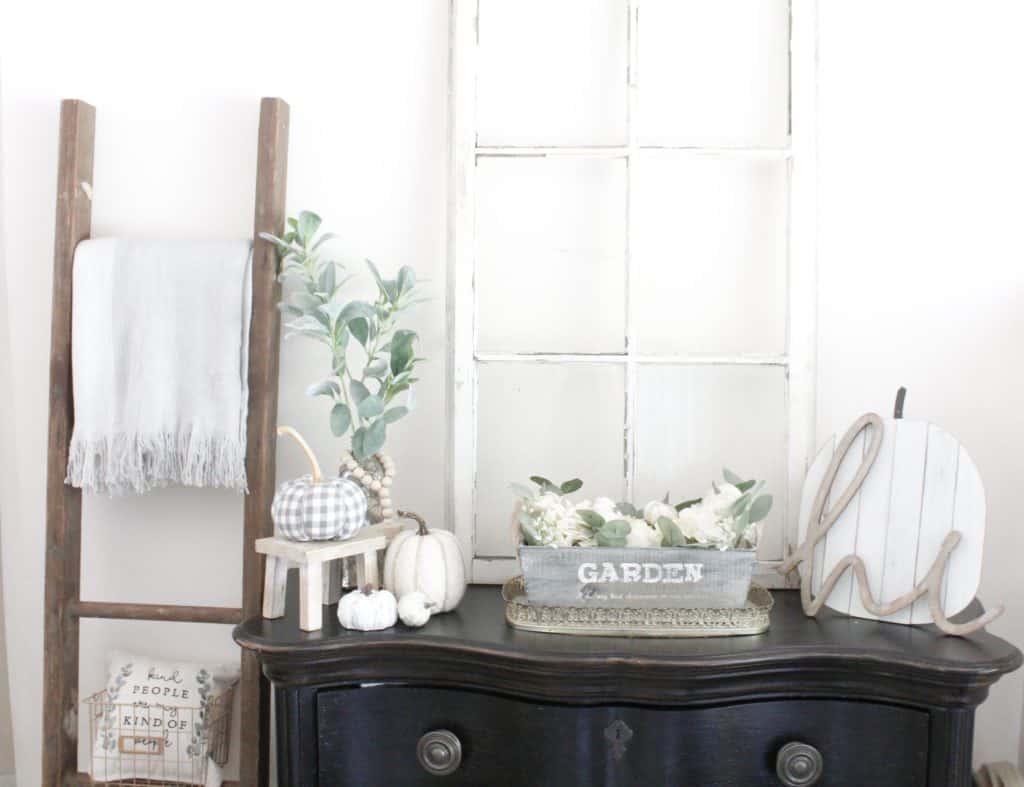 This fall display is on our entryway table. I added several different pumpkins in different neutral colors, materials, and sizes. I love the layered wooden "hi" sign over the wood pumpkin. The vintage window and ladder really add to that farmhouse decor feel.