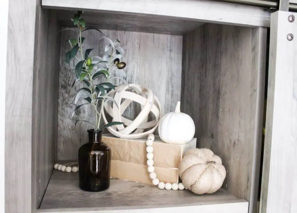 This little cubby is on our bookshelf. I added that amber vase and olive branch and the 2 different pumpkins to bring in that fall decor feel. .