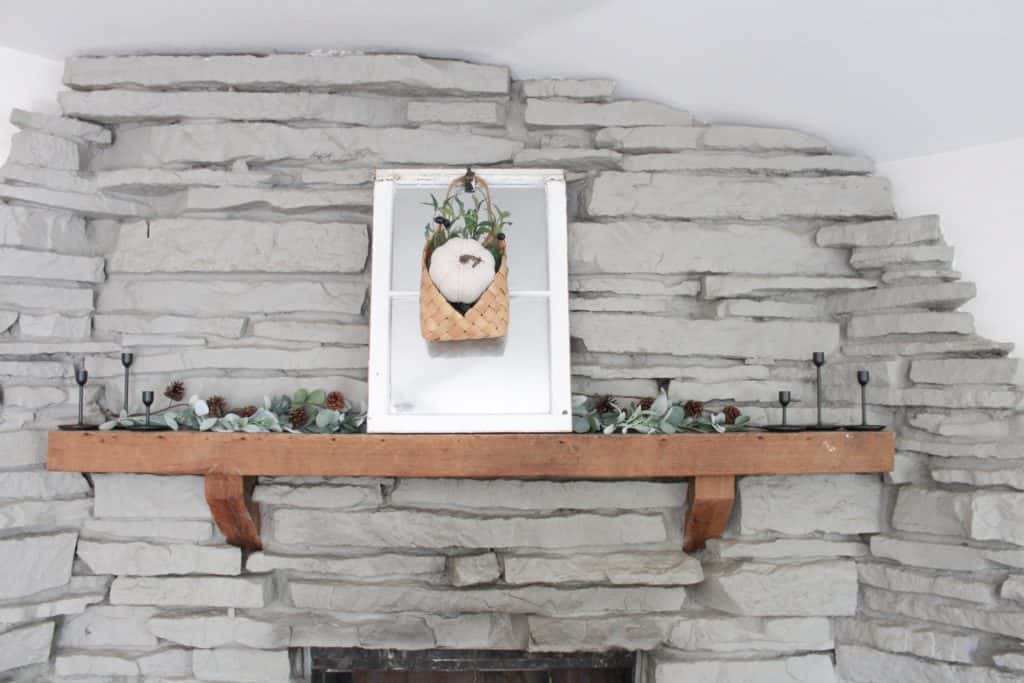 Our fall mantle decor. Netural colors mixed with the warmth of wood and he green of the faux garlands and stems.