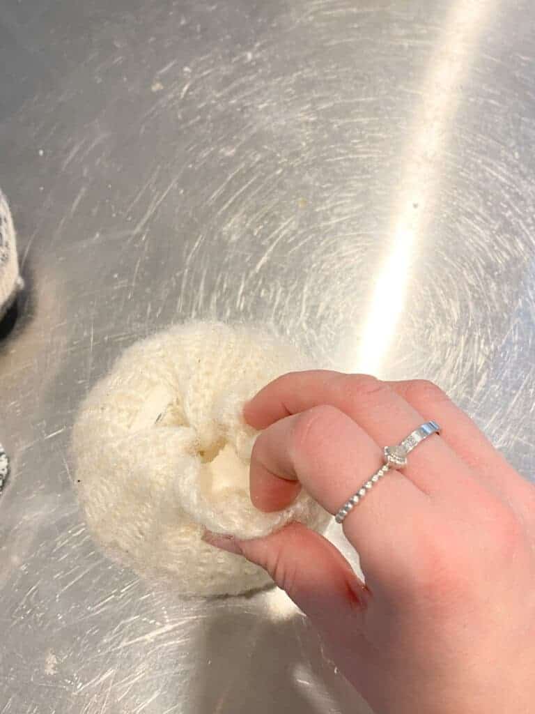 This photo shows how I took one part of the fabric at a time and poked in into the hole I carved in the foam pumpkin, using my finger.