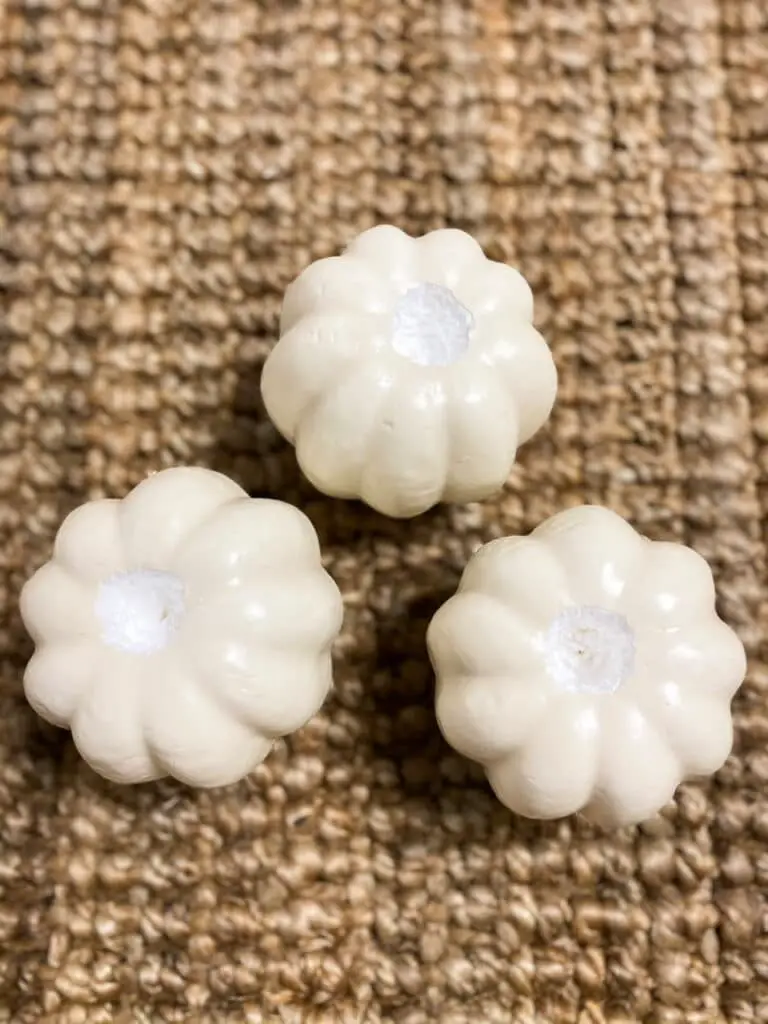 A photo of the three white foam pumpkins after I carved a 2" hole into each of them.