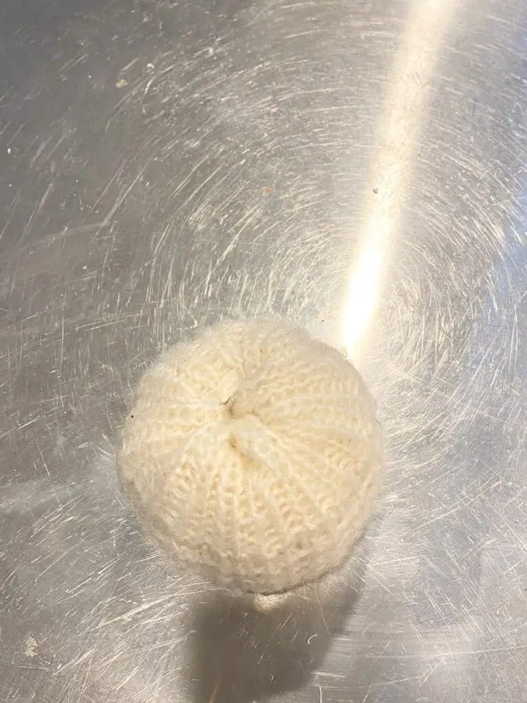 This photo shows how the pumpkin should look once all of your sweater material has been tucked into the hole that was carved out of the foam pumpkin.