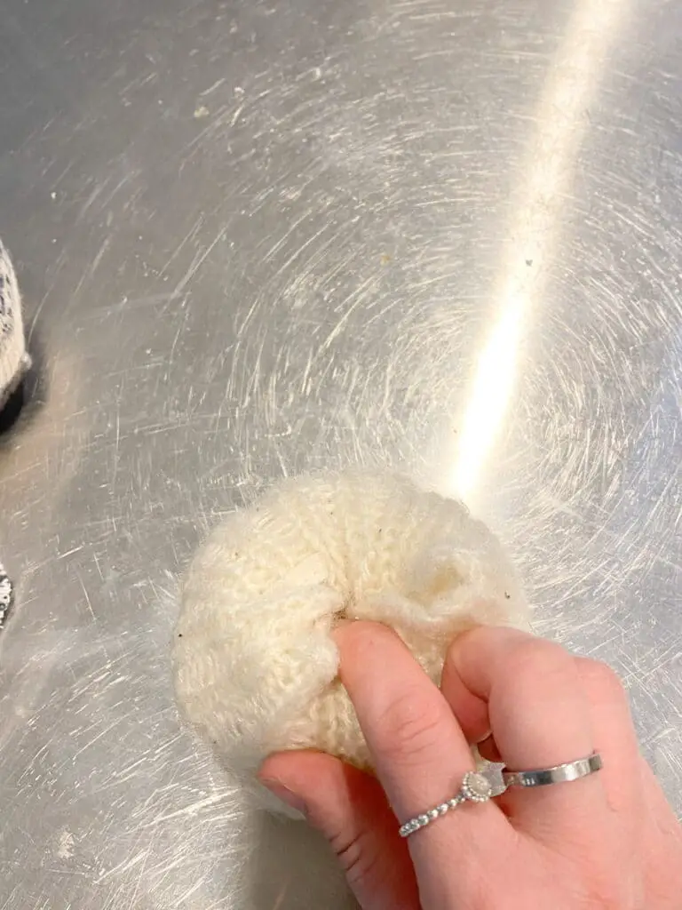 This photo shows how I took one part of the fabric at a time and poked in into the hole I carved in the foam pumpkin, using my finger.