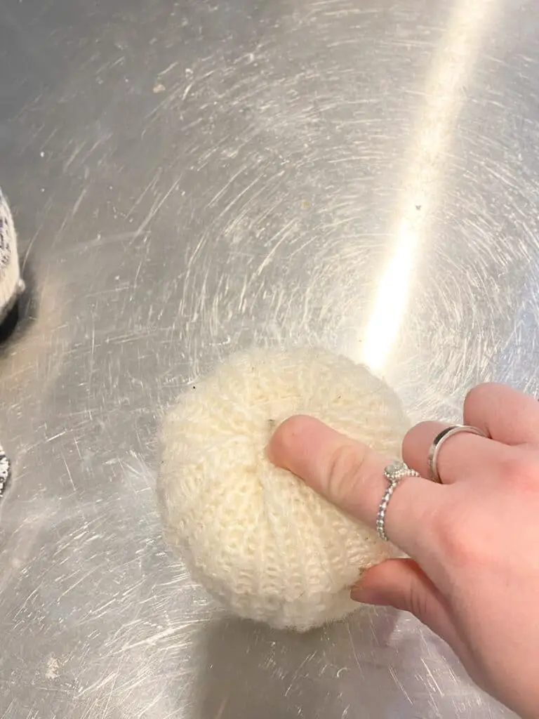 This photo shows how I took one part of the fabric at a time and poked in into the hole I carved in the foam pumpkin, using my finger.