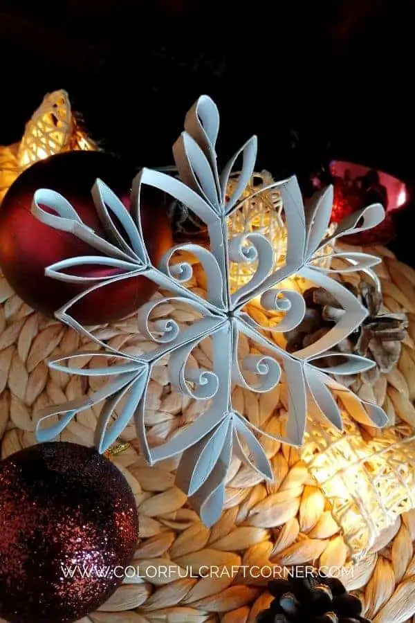 Snowflakes made from toilet paper rolls and painted white. Set on top of some red ornaments and white pinecones and lights.
