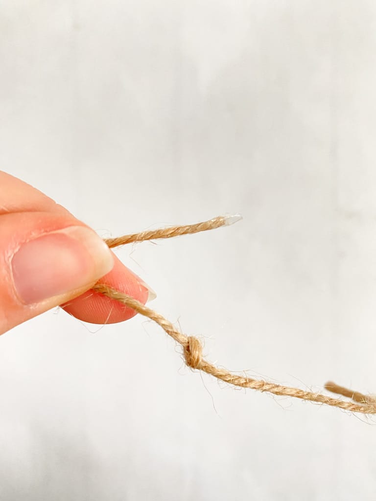 Put a piece of tape on the end of your twine to make it easier to string the wood beads.