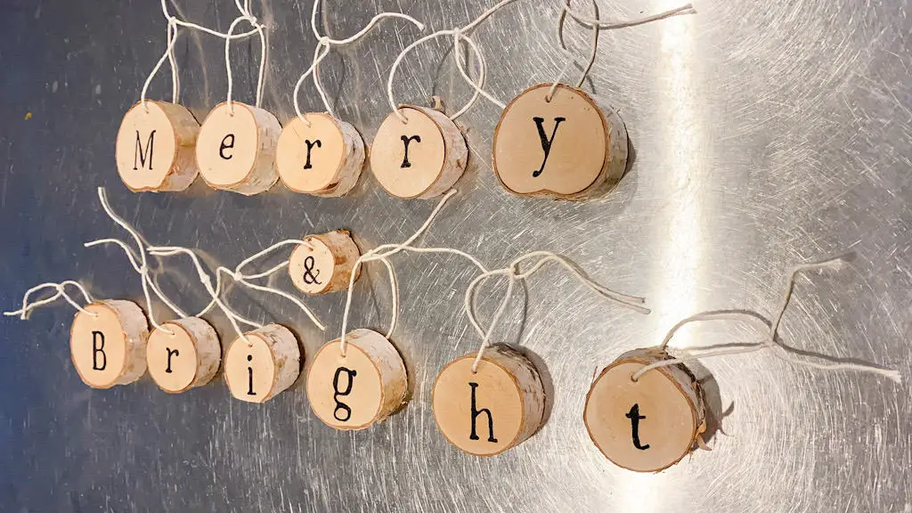wood slices with the words Merry & Bright written on them with cream string tied to them,