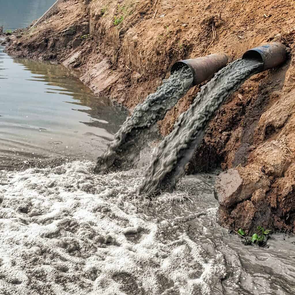 Photo shows polluted water being dumped into a natural body of water. One of the benefits of shopping second hand is that you lessen the demand for new clothing to be produced and therefore less water pollution will occur.