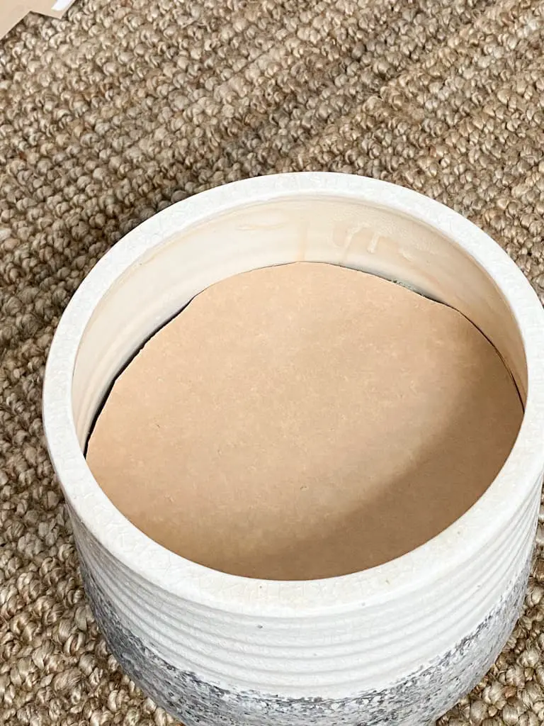 The cut cardboard circle set inside the pot.