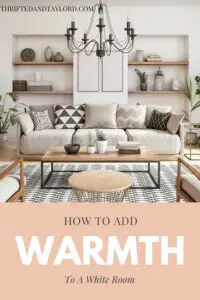 A neutral colored living room with wood accents, a patterned rug, some potted plants, a black metal candelabra style chandelier, there are some wood shelves built into the walls with various vases and other odd and end home deco pieces.