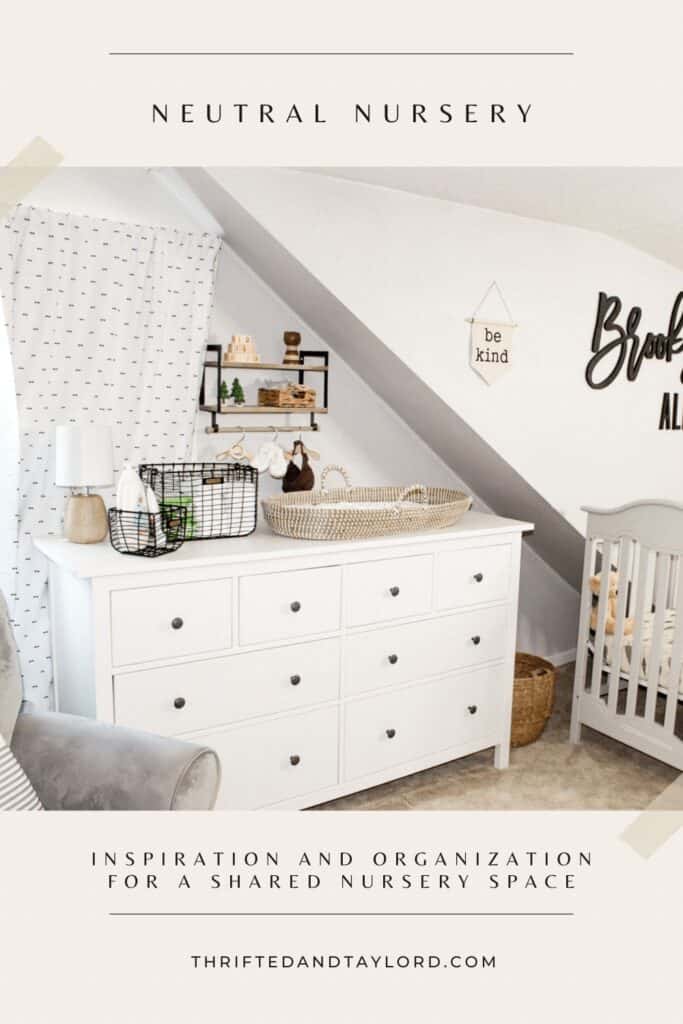 If you share a bedroom with baby then finding furniture that can house a lot of items is very helpful. Photo shows a white 8 drawer dresser with a changing station on top, a wall mounted shelf with wood baby toys and decorations and some baby accessories hanging on wood hangers on a hang bar below. There is a gray crib, a wall banner that says "be kind" and a black wood cutout of the name Brooks Alexander.