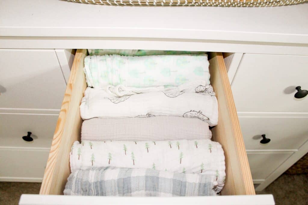 A drawer with folded muslin swaddle blankets.