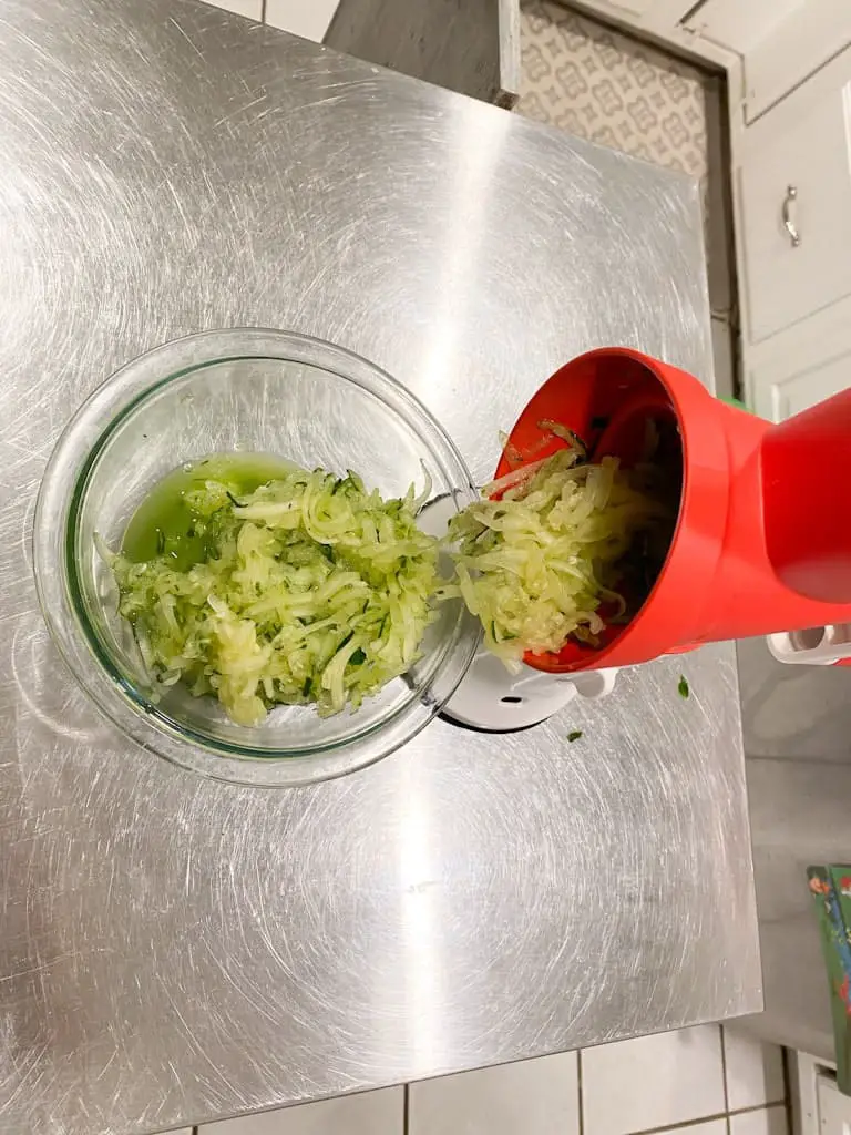 The Tupperware Grate Master as it is grating cucumber using the fine grating cone, the cucumber is going into a bowl.