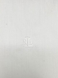 Close up showing the Ralph Lauren emboridery on the white collared button down shirt.