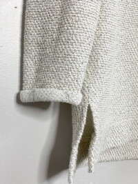 Close up photo of textured sweatshirt with rolled sleeves.