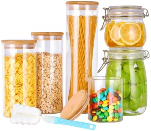 Mixture of glass containers with wooden lids and airtight glass containers, perfect for DIY pantry organization.