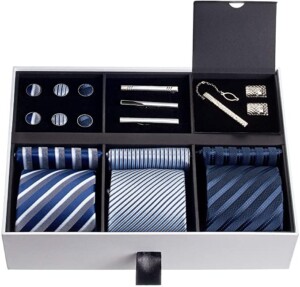 A men's accessory gift box set including 2 blue patterned ties, 3 cufflinks in varying shades of blue, 3 tie clips, and a tie clip with matching cufflinks. This makes such a great gift for him he will actually use.