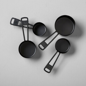 A set of 5 black metal measuring cups. Perfect gift for someone who loves to bake and cook.