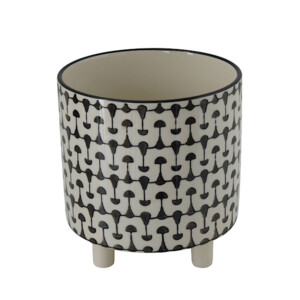 A black and white patterned ceramic planter with little feet.