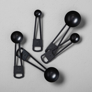 A set of 5 black metal measuring spoons. Perfect gift for someone who loves to bake and cook.