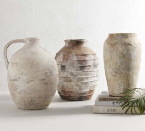 a set of 3 aged earthenware vases in cream and light neutral colors with lots of texture.